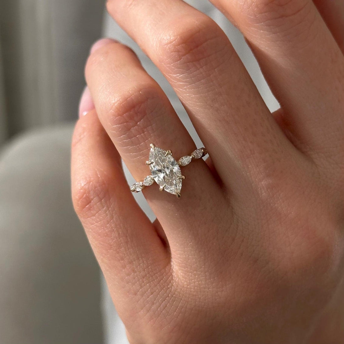 Marquise cut moissanite engagement ring with spaced marquise accent band in yellow gold