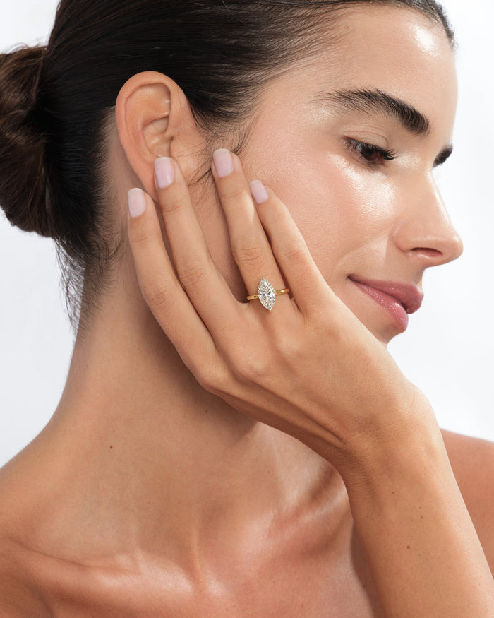 Marquise lab grown diamond minimalist ring in yellow gold worn with the hand against the cheek