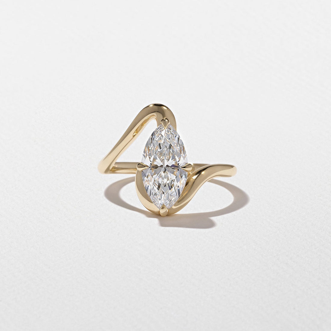 Marquise cut moissanite sculptural swirl solitaire engagement ring in yellow gold