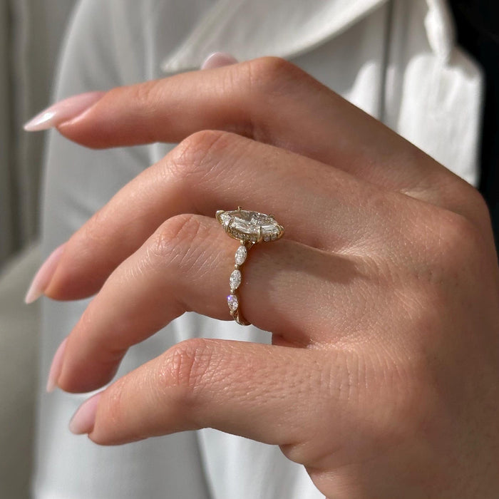 Marquise cut moissanite engagement ring with trailing marquise accent band in yellow gold, view 2