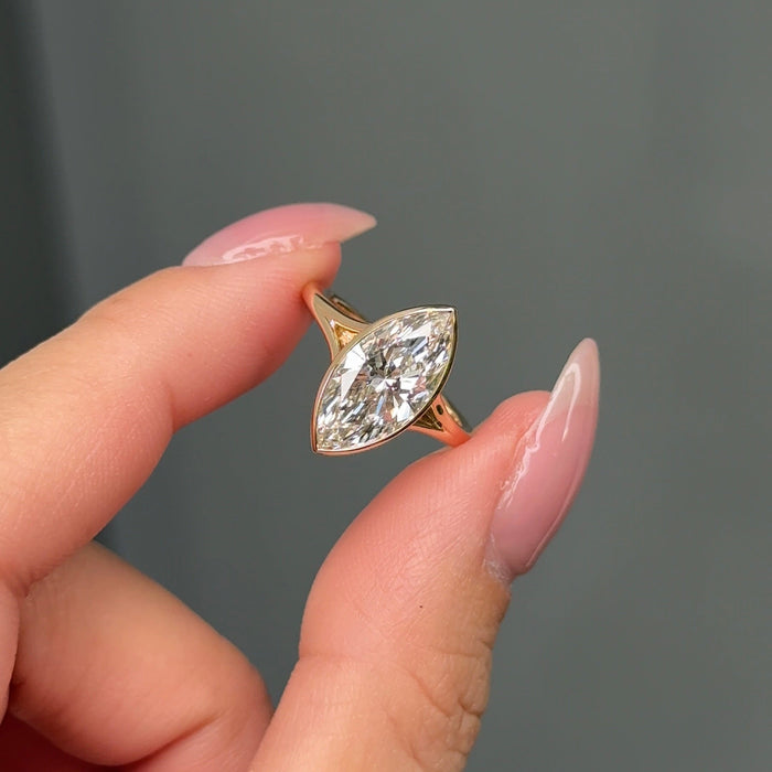 Marquise cut moissanite tapered bezel solitaire engagement ring in yellow gold