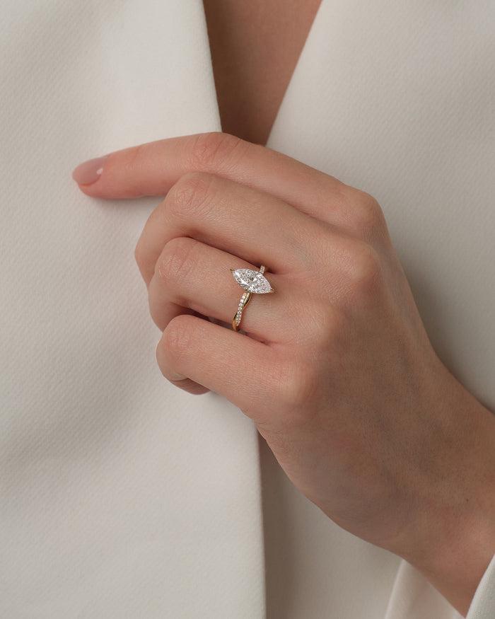 Marquise moissanite braided pave ring in yellow gold worn on the hand at a white jacket