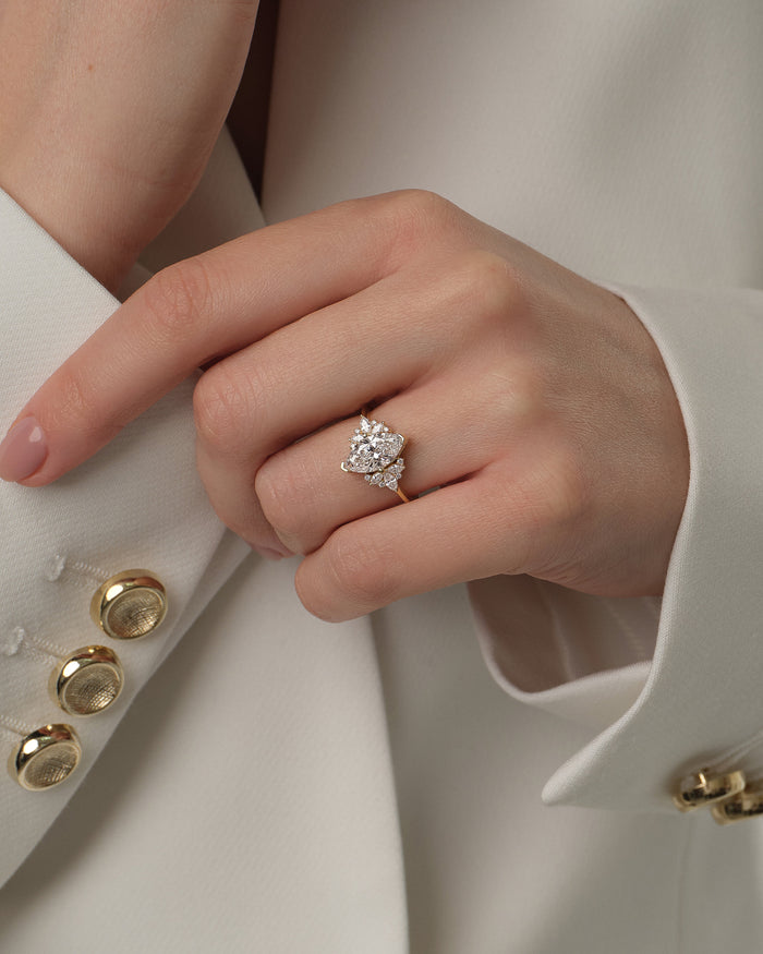 Marquise moissanite vintage cluster engagement ring in yellow gold worn on the hand at the cuff