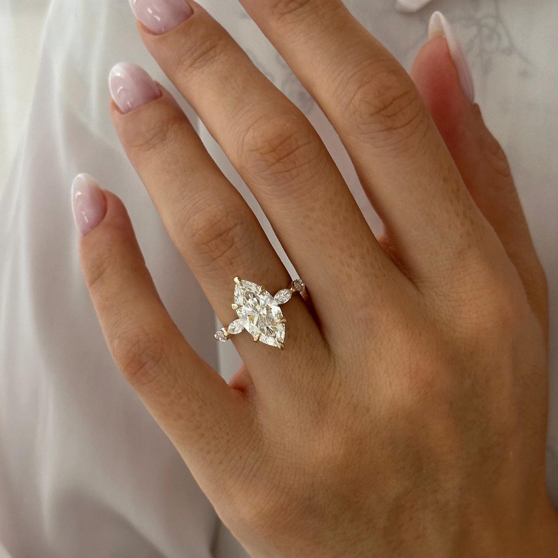Marquise cut moissanite engagement ring with angled marquise wing accents in yellow gold