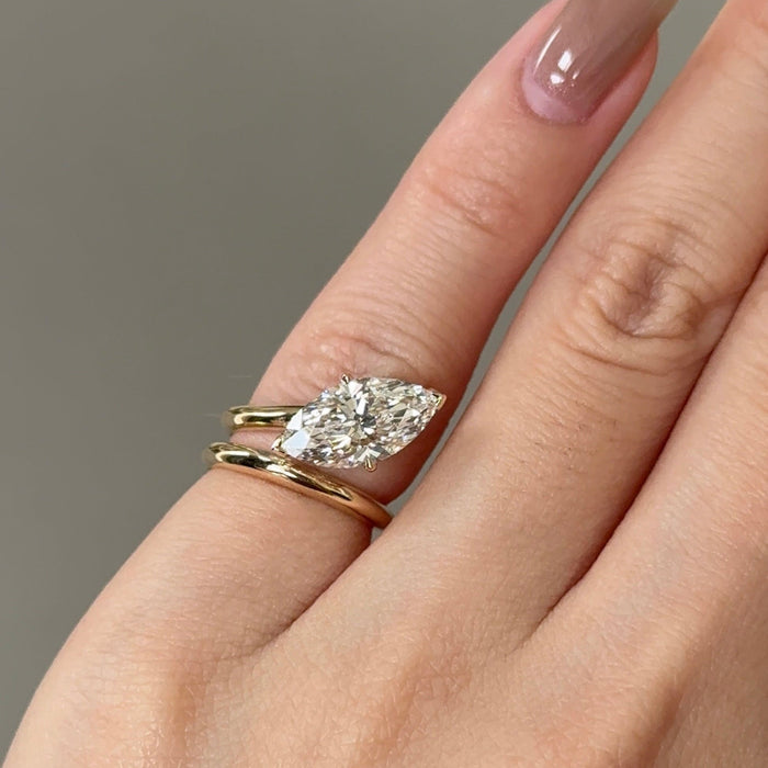 East west marquise moissanite solitaire engagement ring on a wrap shank in yellow gold