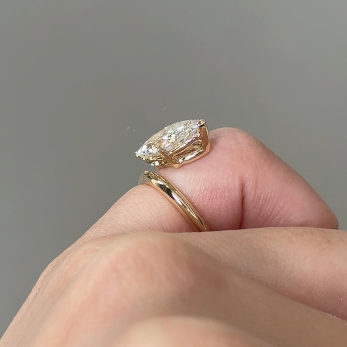 East west marquise moissanite solitaire engagement ring on a wrap shank in yellow gold, view 2