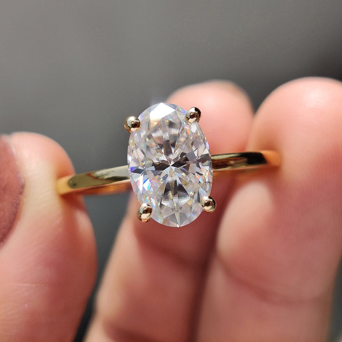 Oval cut moissanite ball claw solitaire engagement ring on a flat hairline rose gold band, view 2