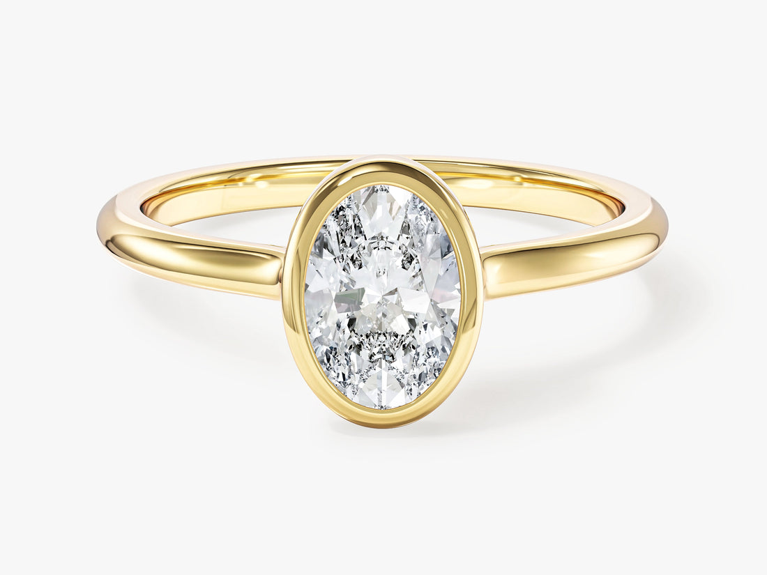 Dainty oval moissanite bezel engagement ring in yellow gold, front view
