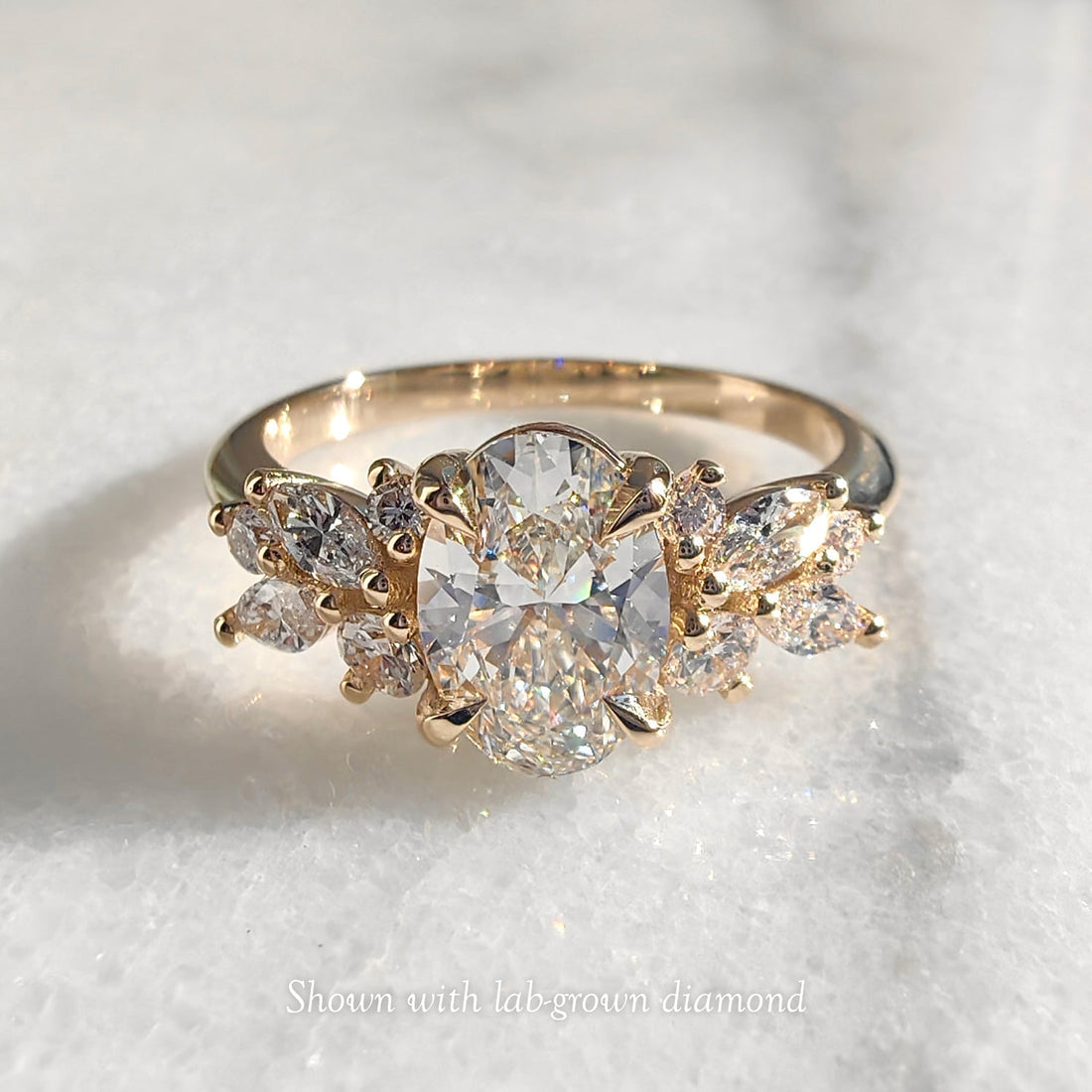 Oval cut moissanite butterfly wing mixed cluster engagement ring in yellow gold