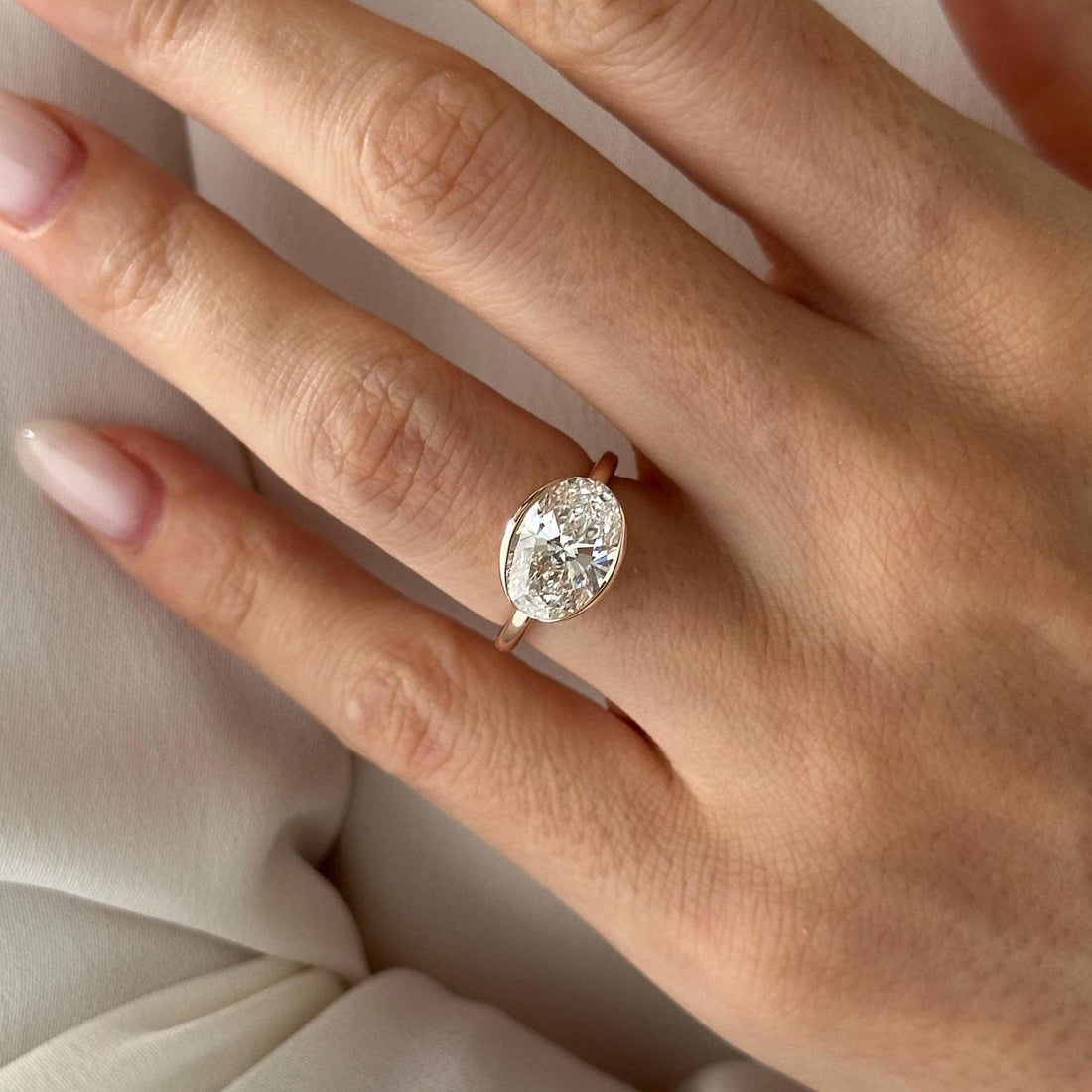 Oval cut moissanite bezel set solitaire engagement ring in rose gold