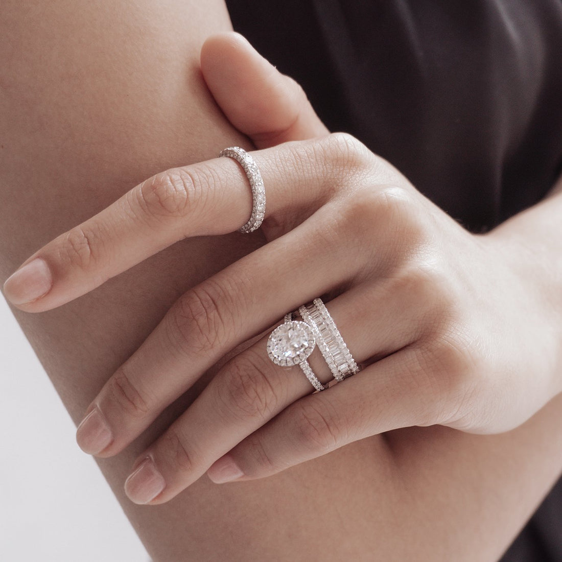 Oval cut moissanite close fitted halo engagement ring on a pave band in white gold