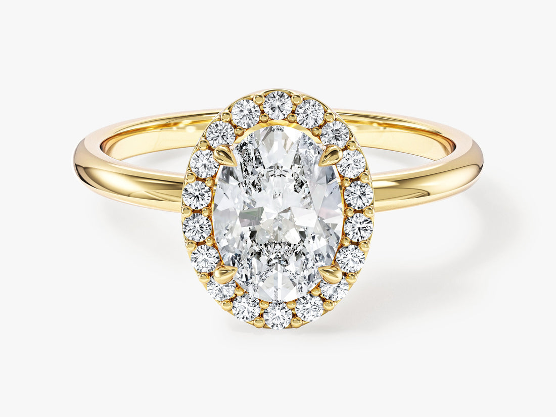 Oval cut moissanite halo engagement ring with slim polished band in yellow gold, front view