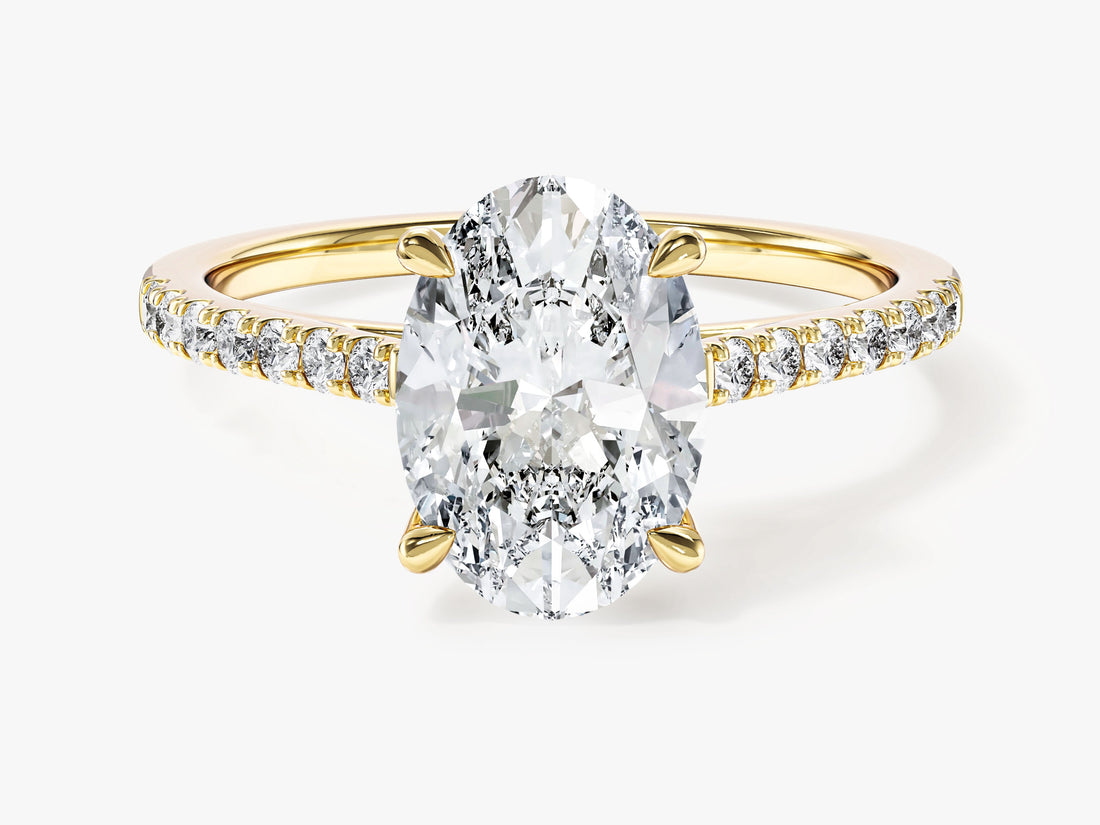Oval cut moissanite cathedral engagement ring with pave band in yellow gold, front view