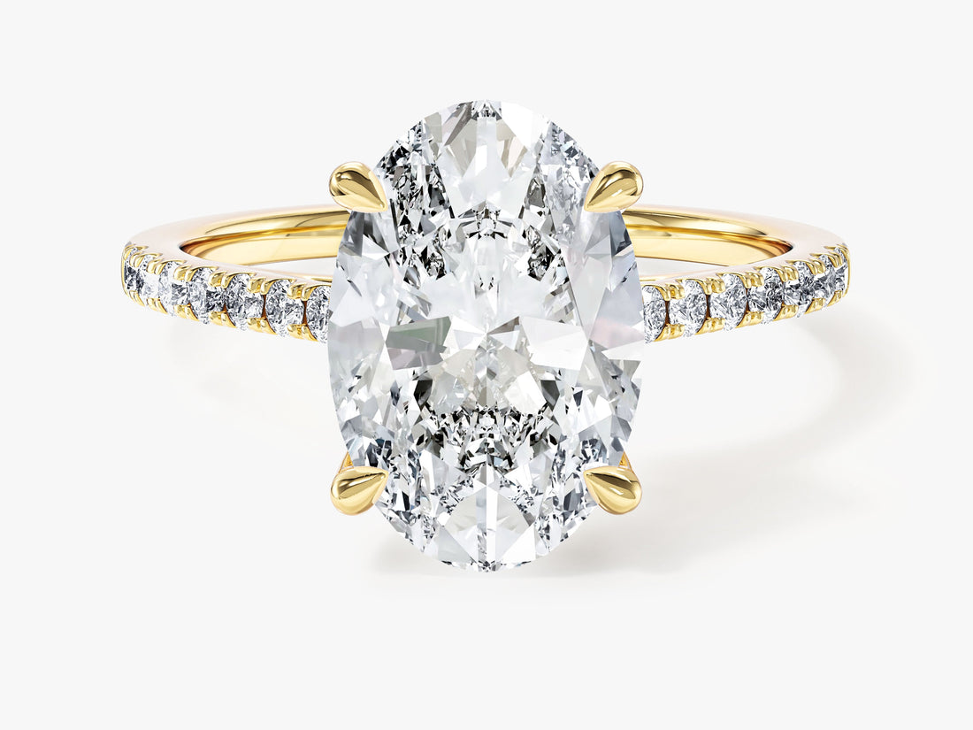 Large oval moissanite cathedral engagement ring with micro pave band in yellow gold, front view