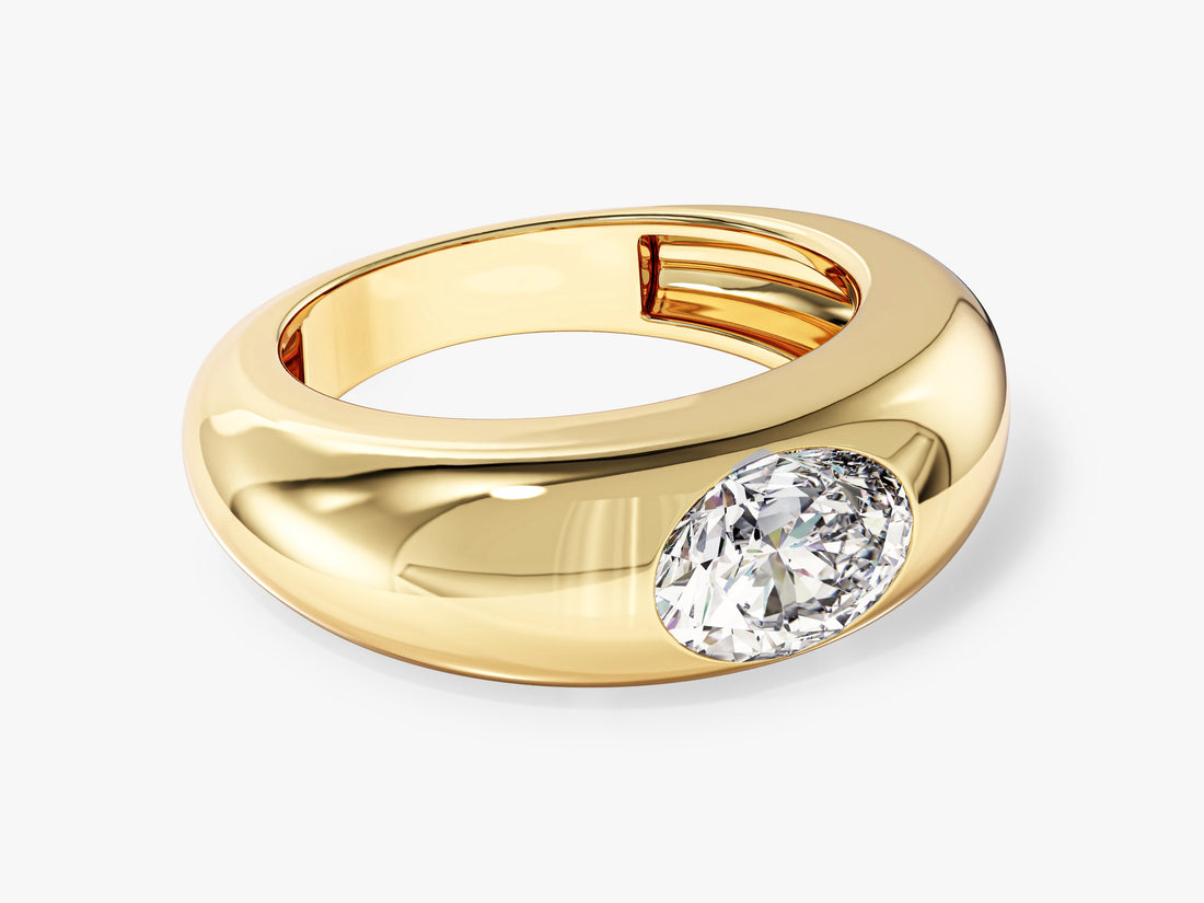 Oval lab grown diamond bold dome ring with a flush set east west stone in yellow gold, angled view