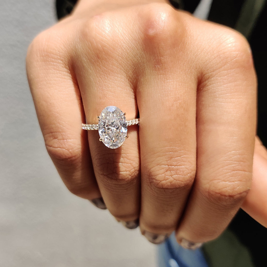 Oval cut moissanite double claw hidden halo engagement ring on a pave shank in rose gold