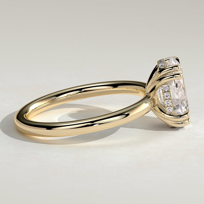 Oval cut moissanite double claw solitaire engagement ring on a knife edge yellow gold band, view 2