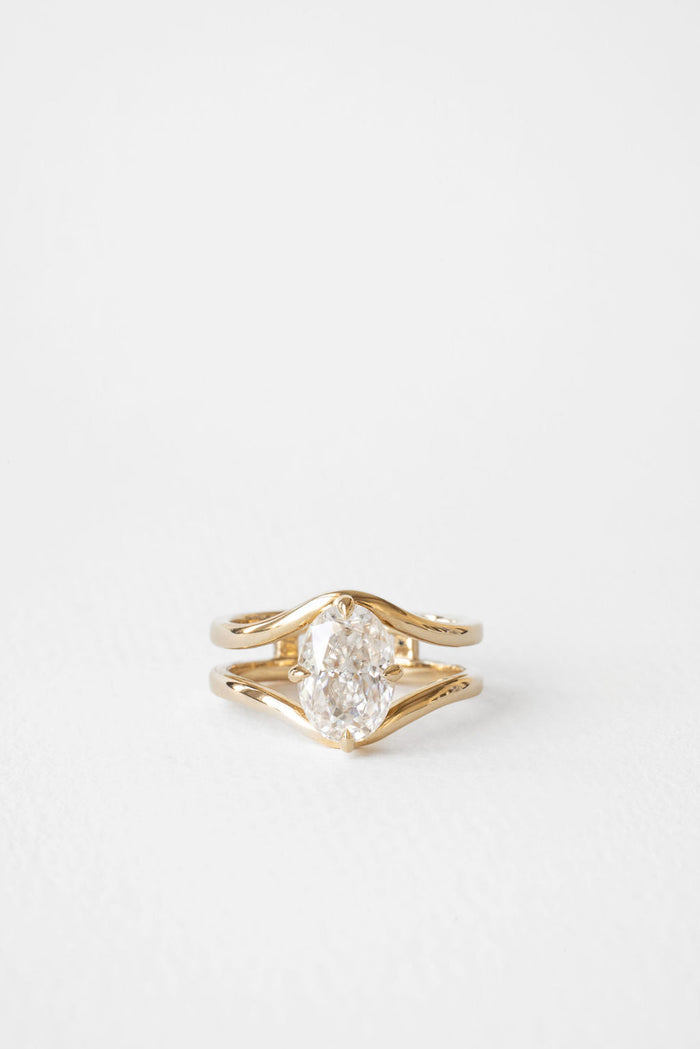Oval cut moissanite double curved rail solitaire engagement ring in yellow gold