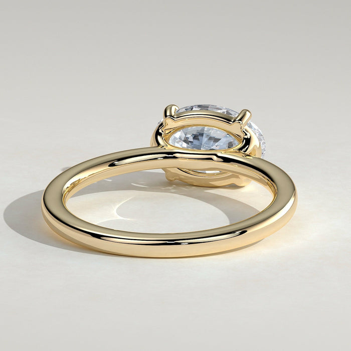East west oval moissanite four claw solitaire engagement ring on a plain yellow gold band, view 2