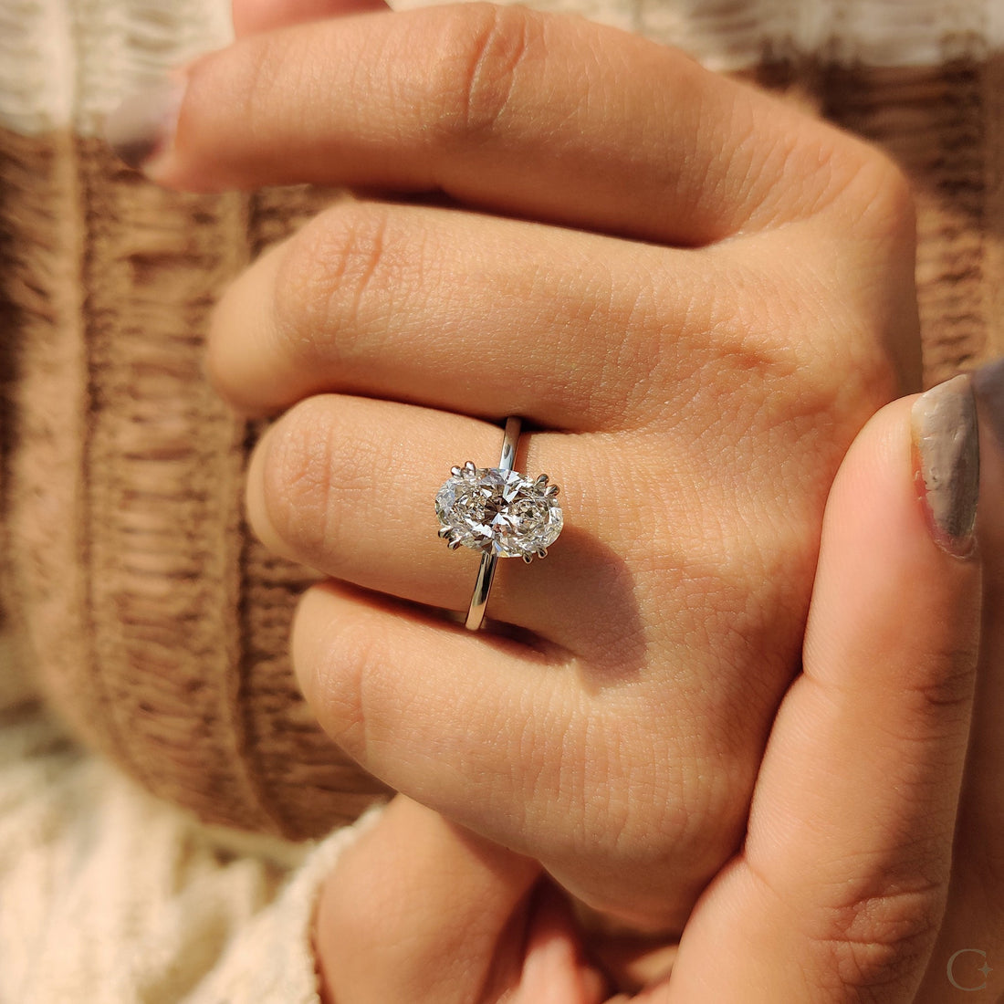 Oval cut moissanite eight claw solitaire engagement ring on a rounded white gold band