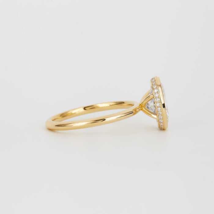 Oval cut moissanite full bezel solitaire engagement ring on a fine yellow gold band, view 2