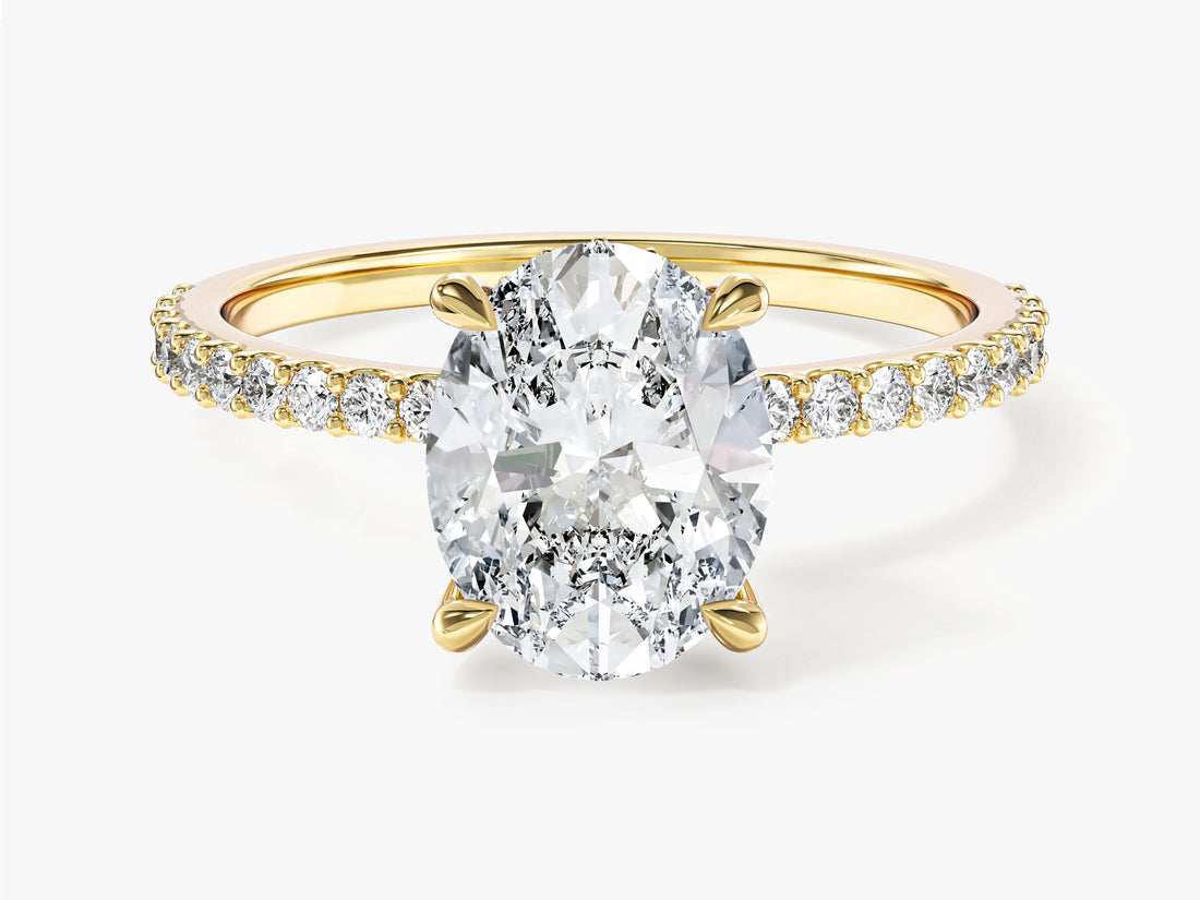 Four prong oval lab grown diamond engagement ring with diamond side stone band in yellow gold, front view