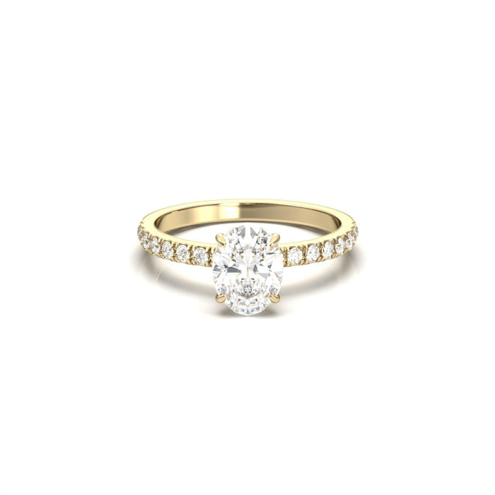 Oval cut moissanite four claw engagement ring on a French pave shank in yellow gold
