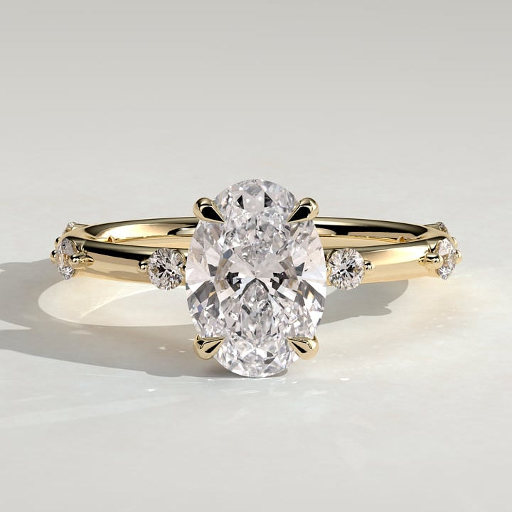 Oval cut moissanite engagement ring with graduated spaced accents in yellow gold