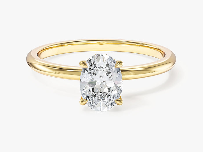Dainty oval moissanite hidden halo engagement ring with slim yellow gold band, front view