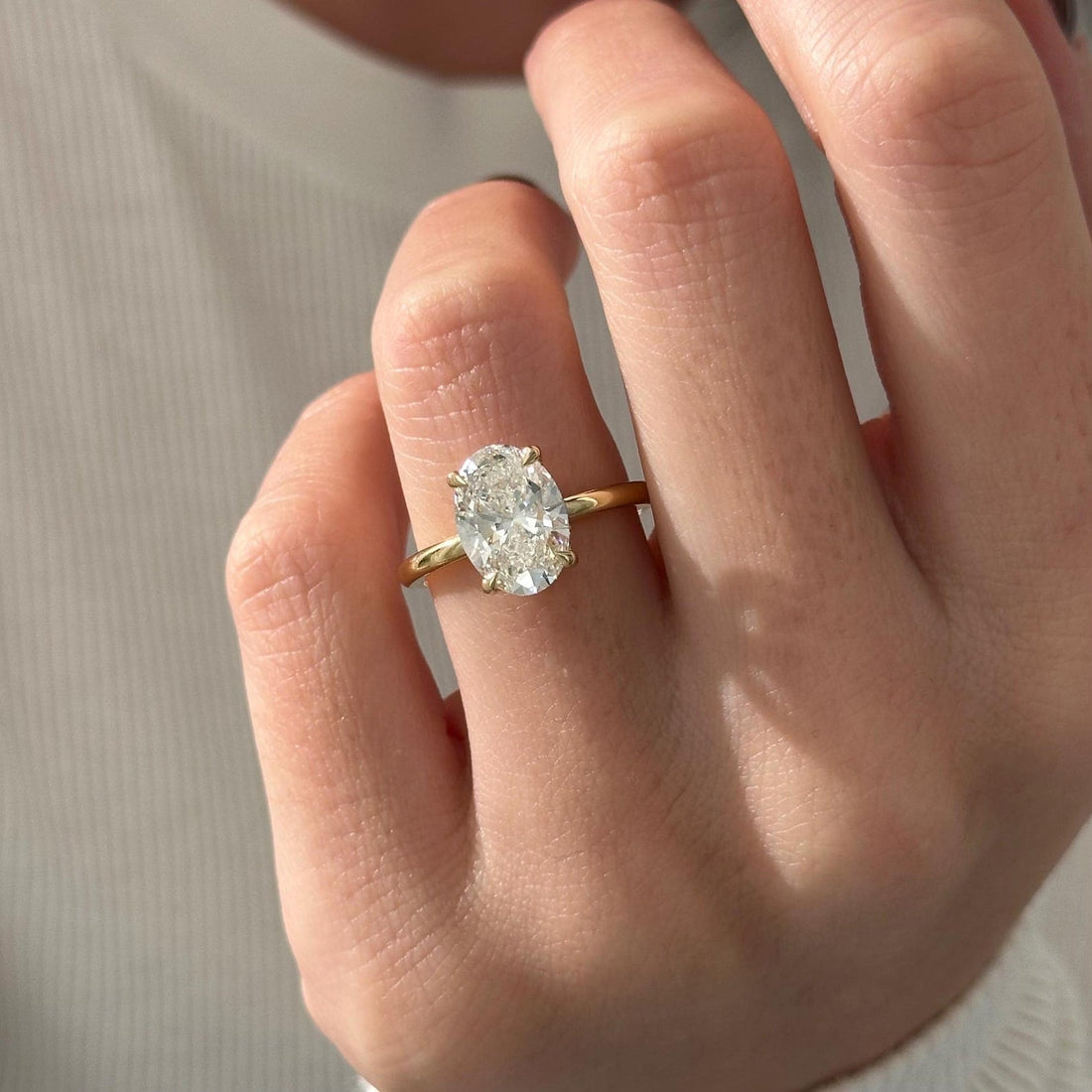 Oval cut moissanite hidden halo engagement ring in yellow gold