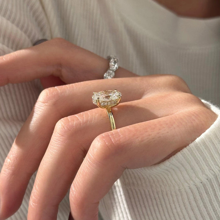 Oval cut moissanite hidden halo engagement ring in yellow gold, view 2