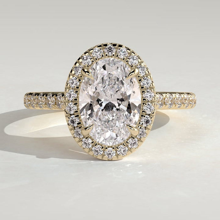 Oval cut moissanite halo engagement ring on a pave yellow gold band