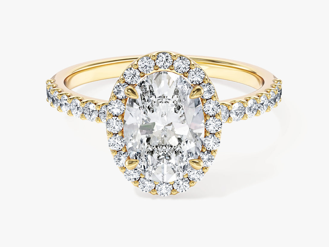 Classic oval moissanite halo engagement ring on a half pave band in 14K yellow gold, front view