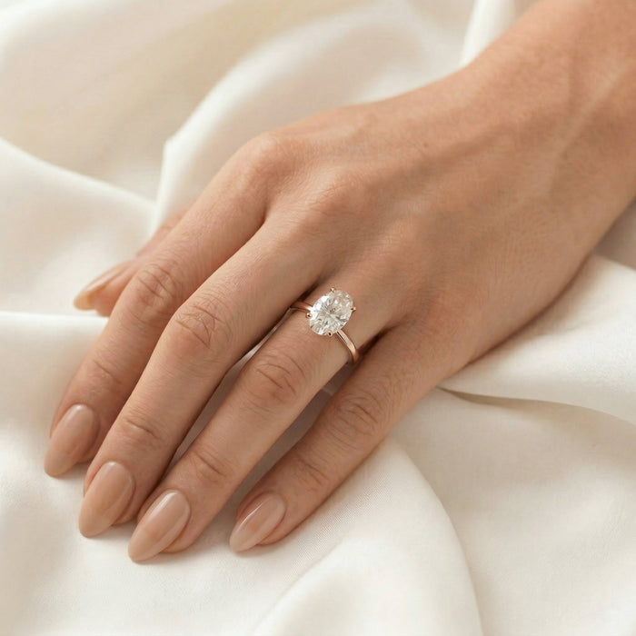 Oval cut moissanite hidden halo engagement ring on a satin finished yellow gold band, view 2