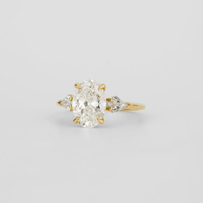 Oval cut moissanite three stone engagement ring with kite cut side stones in yellow gold, view 2