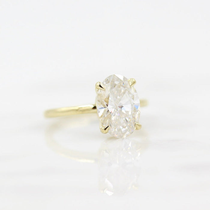 Large oval cut moissanite solitaire engagement ring on a hairline wire yellow gold band, view 2