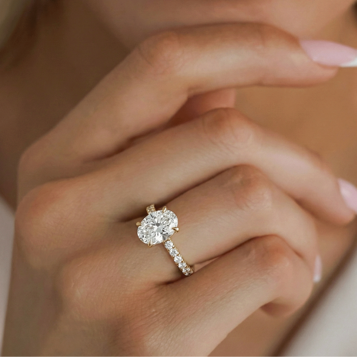 Oval cut moissanite pave band engagement ring in yellow gold