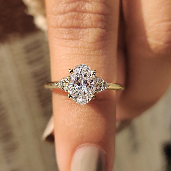Oval cut moissanite petite trio cluster engagement ring on a hairline yellow gold band, view 2