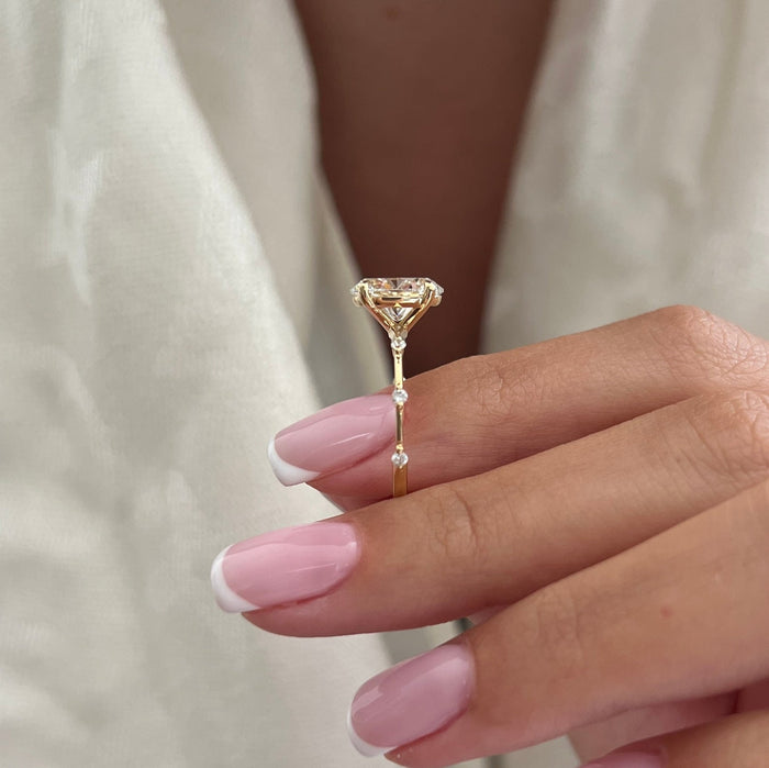 Oval cut moissanite thread band engagement ring with spaced accents in yellow gold, view 2