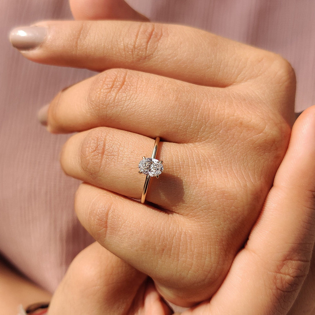 Oval cut moissanite six claw solitaire engagement ring on a flat yellow gold band