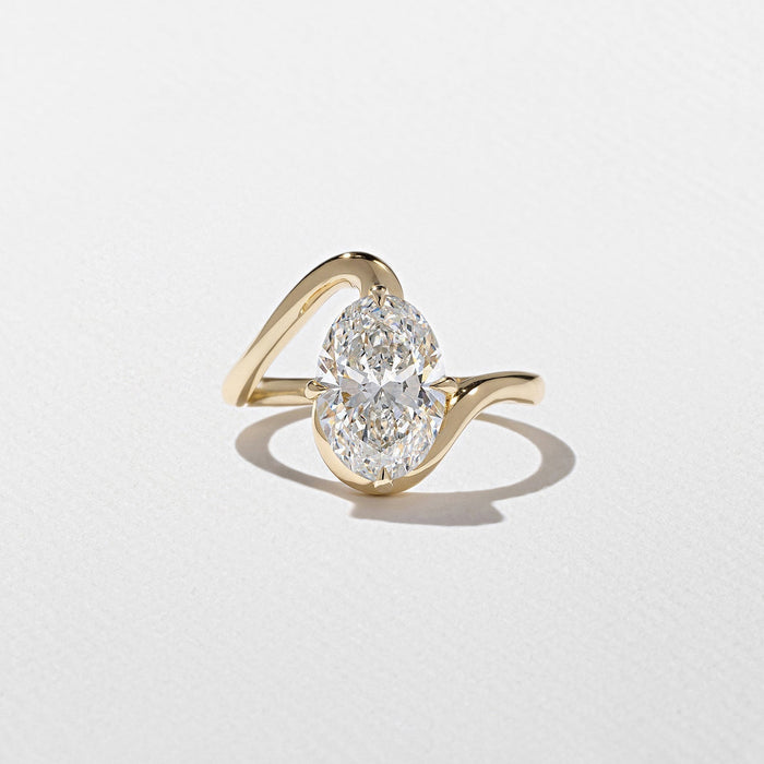 Oval cut moissanite sculptural swirl solitaire engagement ring in yellow gold