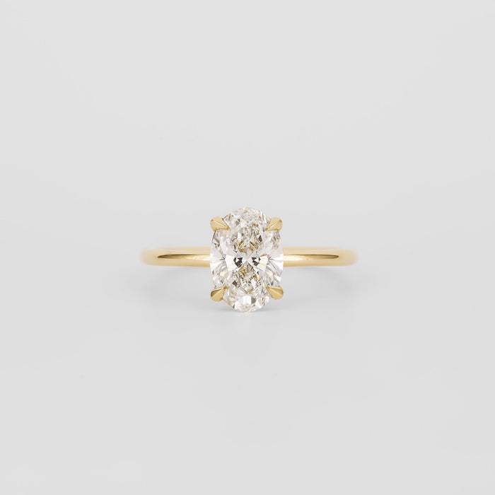 Oval cut moissanite split claw solitaire engagement ring on a plain yellow gold band
