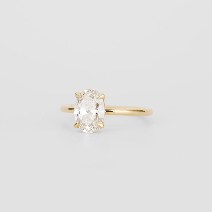 Oval cut moissanite split claw solitaire engagement ring on a plain yellow gold band, view 2