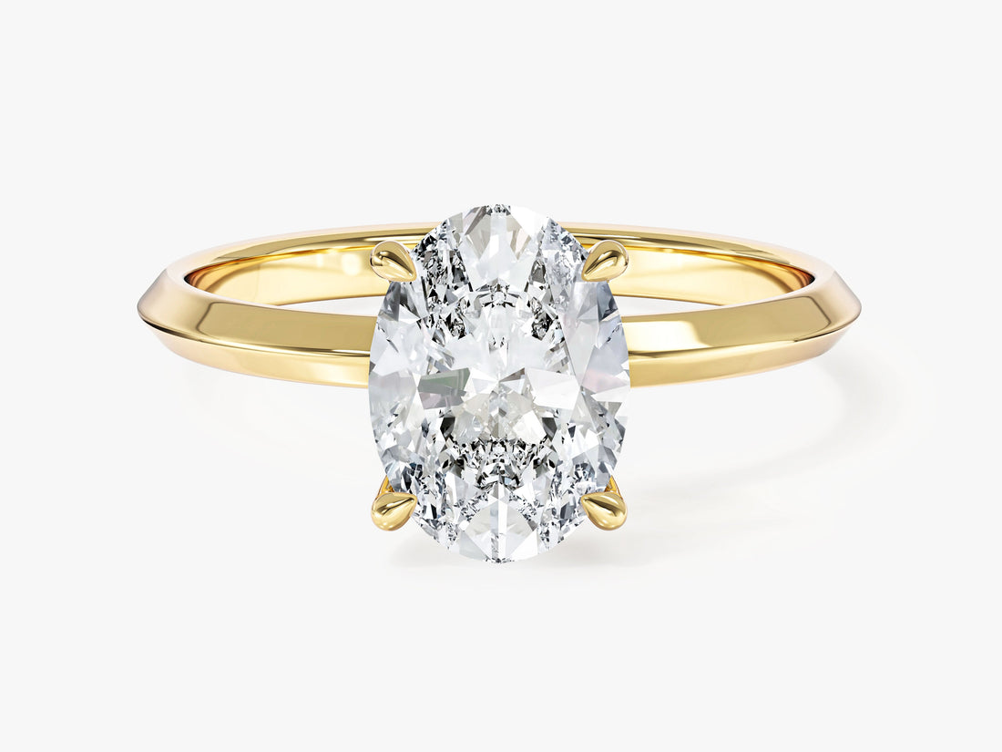 Oval cut moissanite four prong solitaire with knife edge band in 14K yellow gold, front view