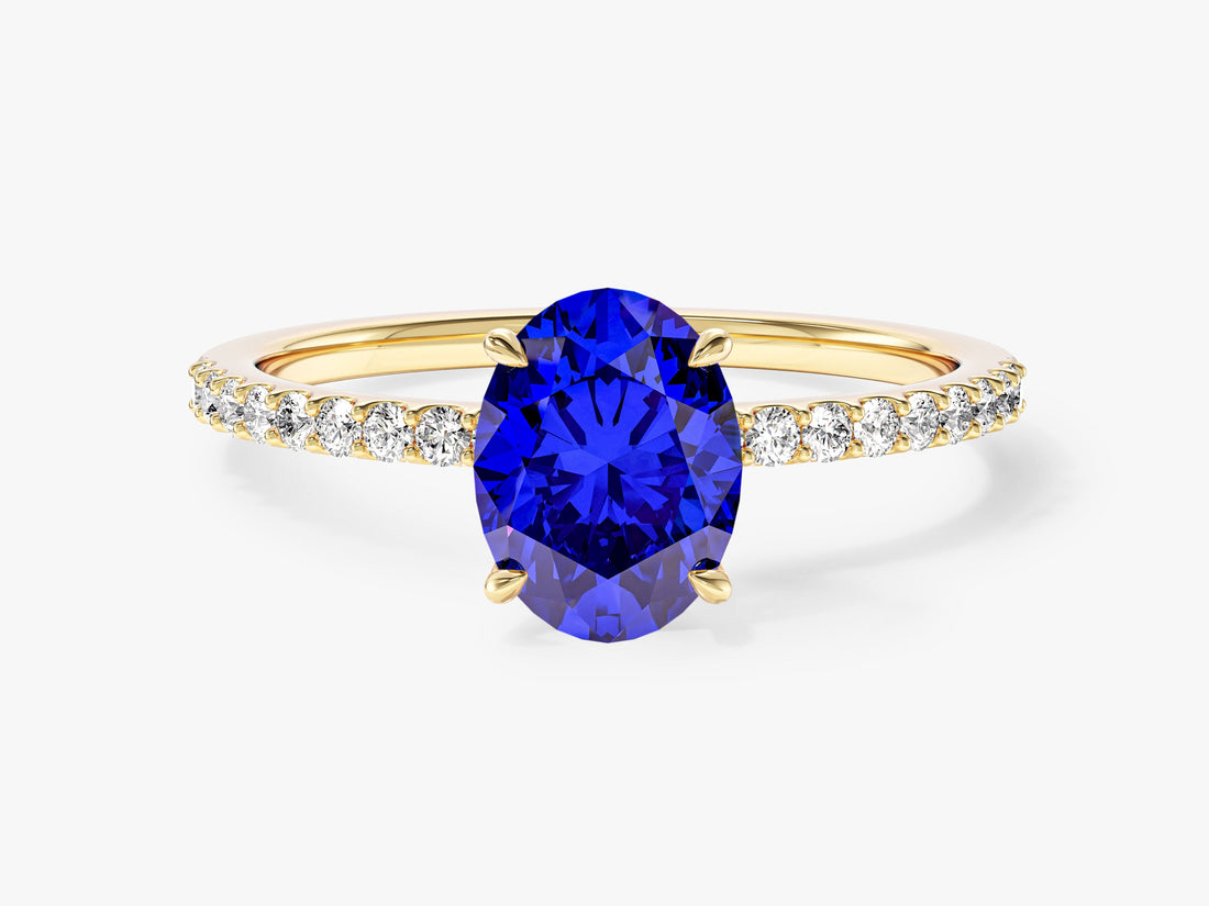Oval moissanite solitaire engagement ring setting with half pave band in 14K yellow gold, shown with a blue display stone