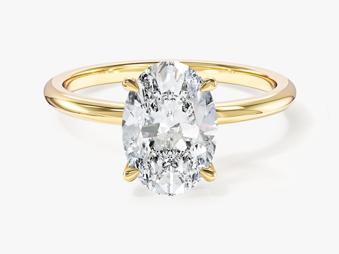 Classic oval moissanite four claw solitaire engagement ring in yellow gold, front view