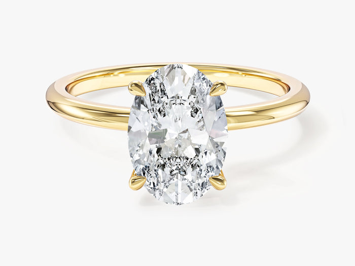 Classic oval moissanite four claw solitaire engagement ring in yellow gold, front view