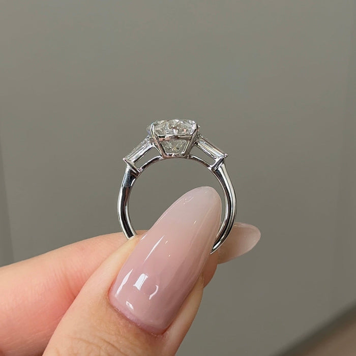 Oval cut moissanite three stone engagement ring with tapered baguette sides in white gold, view 2