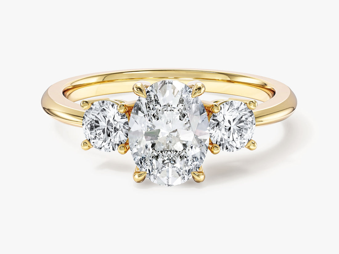 Oval lab grown diamond three stone engagement ring with round side stones in yellow gold, front view