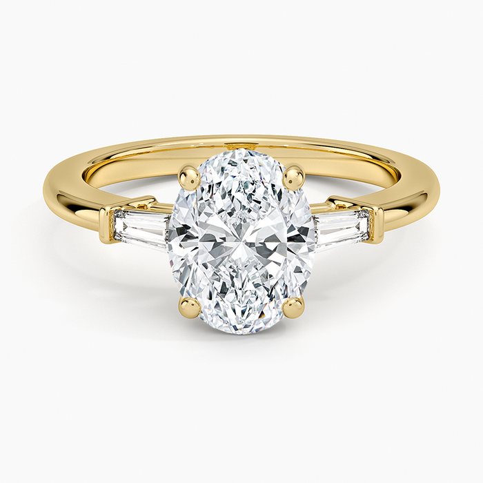 Oval moissanite with bar set tapered baguettes on a plain yellow gold band, top view